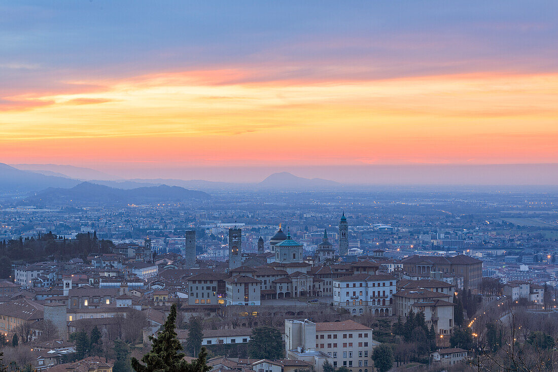 Blick auf die mittelalterliche Altstadt Citta Alta (Oberstadt) auf einem Hügel von den feurigen orange Himmel im Morgengrauen, Bergamo, Lombardei, Italien, Europa