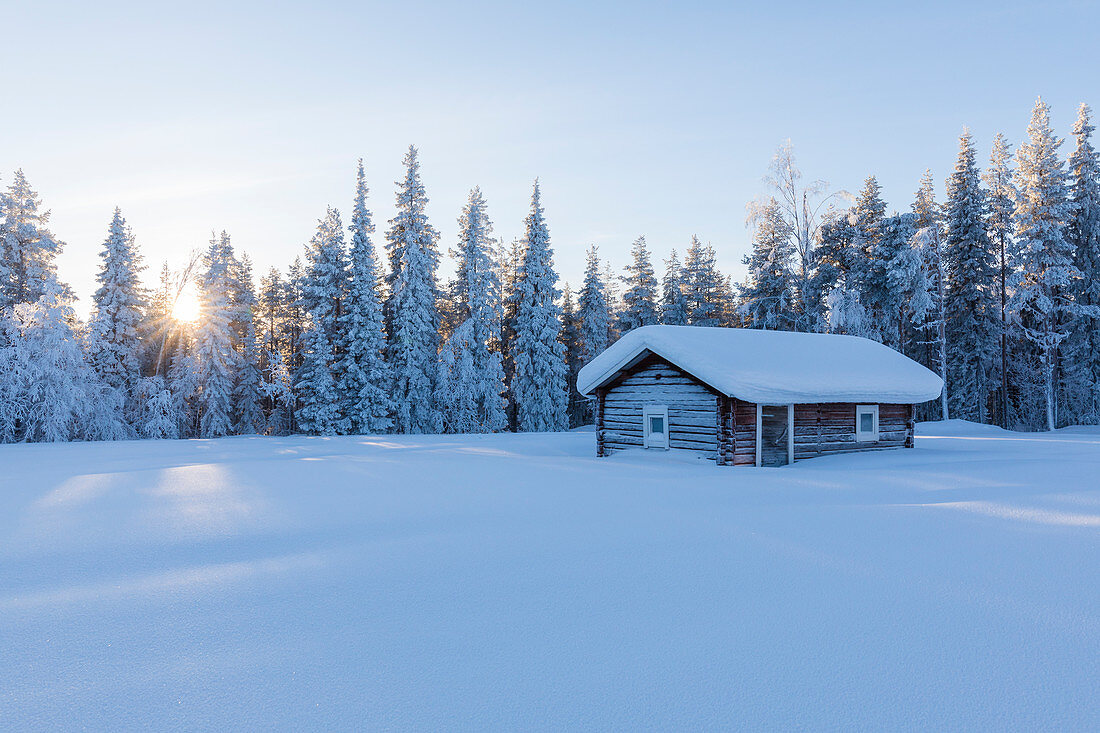 Holzhütte im verschneiten Wald, Kiruna, Norrbotten County, Lappland, Schweden