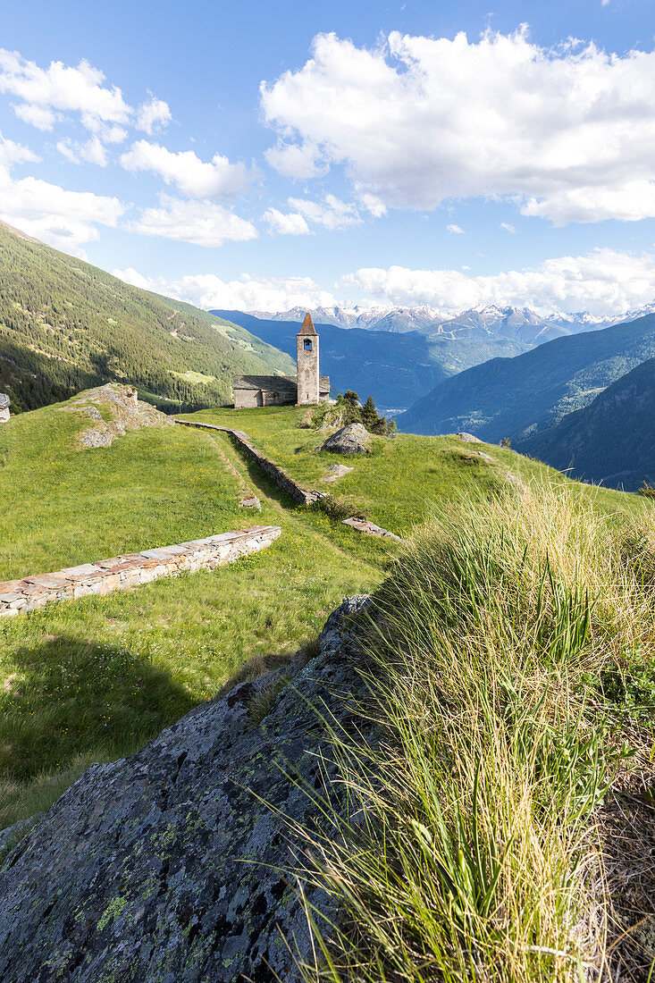 Meadows and old church on the background, San Romerio Alp, Brusio, Canton of Graubünden, Poschiavo valley, Switzerland