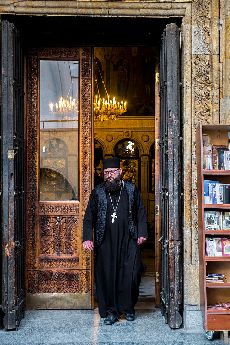 Priest comes out from Sioni Cathedral of the Dormition, Tbilisi, Georgia, Caucaus, Eurasia