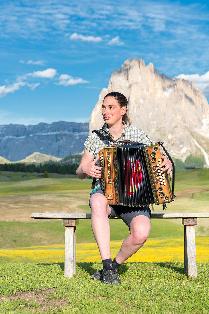 Seiser Alm, Dolomiten, Südtirol, Italien, Junge Frau spielt mit dem Akkordeon auf der Seiser Alm