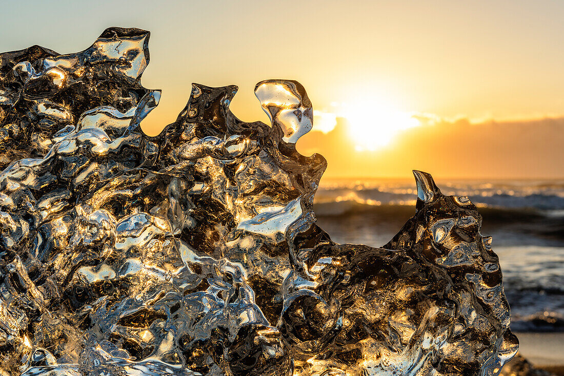 Jokulsarlon glacier lagoon, Iceland. Sunlight reflections over a small black of ice on the shore.