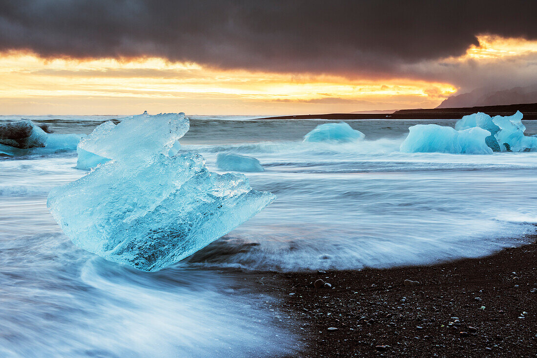 Jokulsarlon, Ostisland, Europa. Eisblöcke am schwarzen Strand in Jokulsarlon Gletscher Lagune während eines Sonnenuntergangs