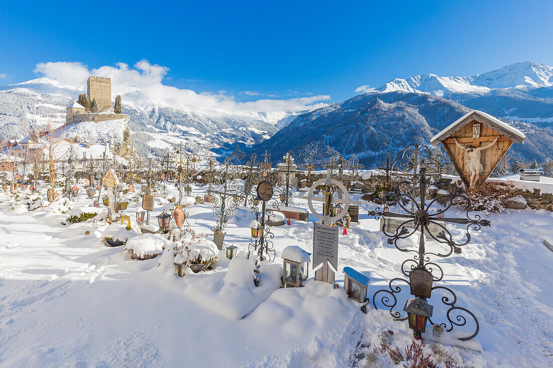 Ladis cemetery with the castle behind. In the background view of Kaunertal. Ladis, Inntal, Tirol, Osterreich, Europe