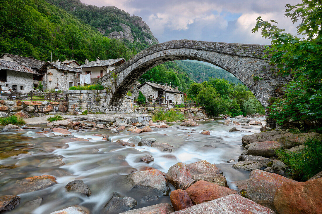 Silk effect waterfall and old (stone, Romanesque) bridge,Fondo, Valchiusella, Piedmont, Italy