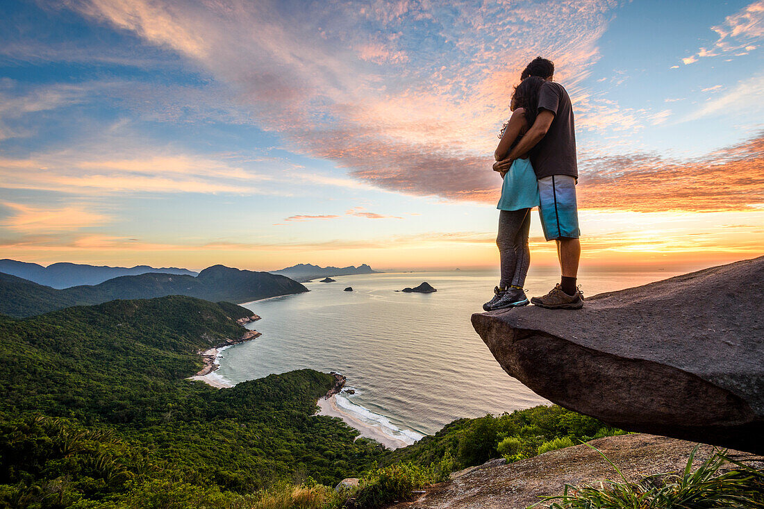 Couple on the edge of the mountain in Pedra do TelÃ©grafo near Barra de Guaratiba, Rio de Janeiro, Brazil