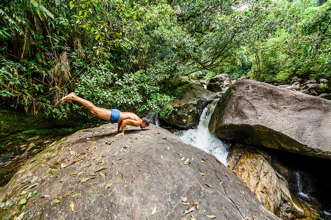 Mann in der Pfauhaltung durch Pirapetinga Fluss in Reservoir Serrinha tun Alambari, Rio de Janeiro, Brasilien