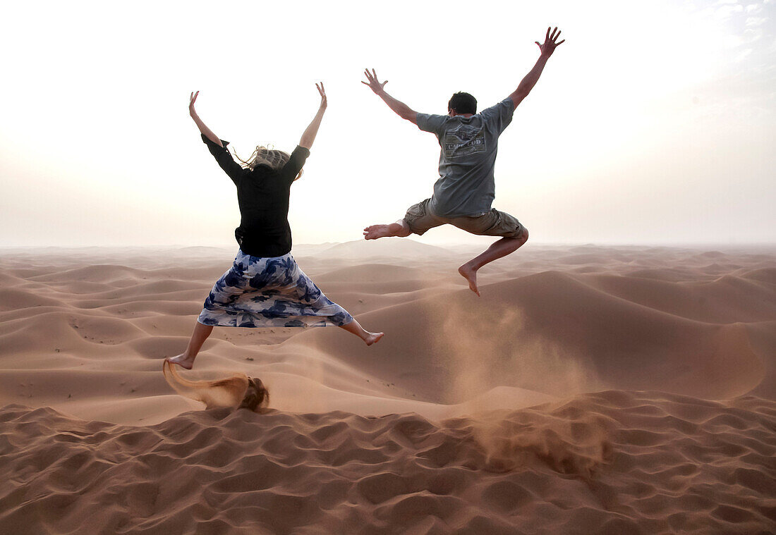 People jump in the Chegaga dunes in the Sahara desert in Morocco.