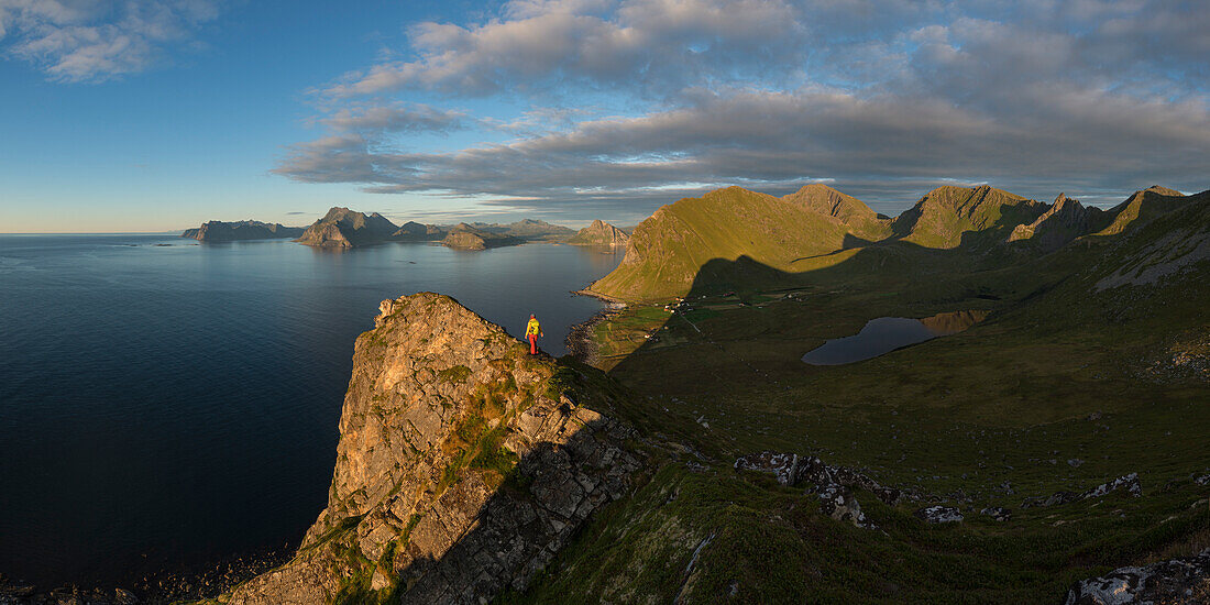 Female hiker on summit of Hornet with panoramic view over Myrland, FlakstadÃ¸y, Lofoten Islands, Norway
