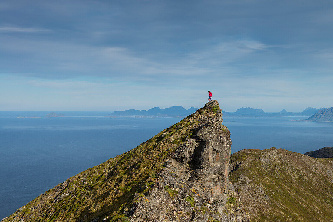 Female hiker descends steep ridge on route to Matmora mountain peak, AustvÃ¥gÃ¸y, Lofoten Islands, Norway