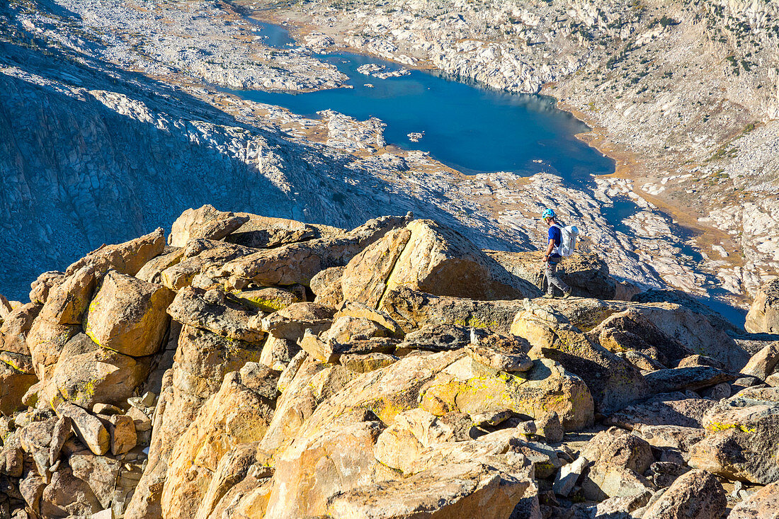 A man hiking along the summit of Mount Mendel along the 8.5 mile Evolution Traverse, John Muir Wilderness, Kings Canyon National Park, Bishop, California.