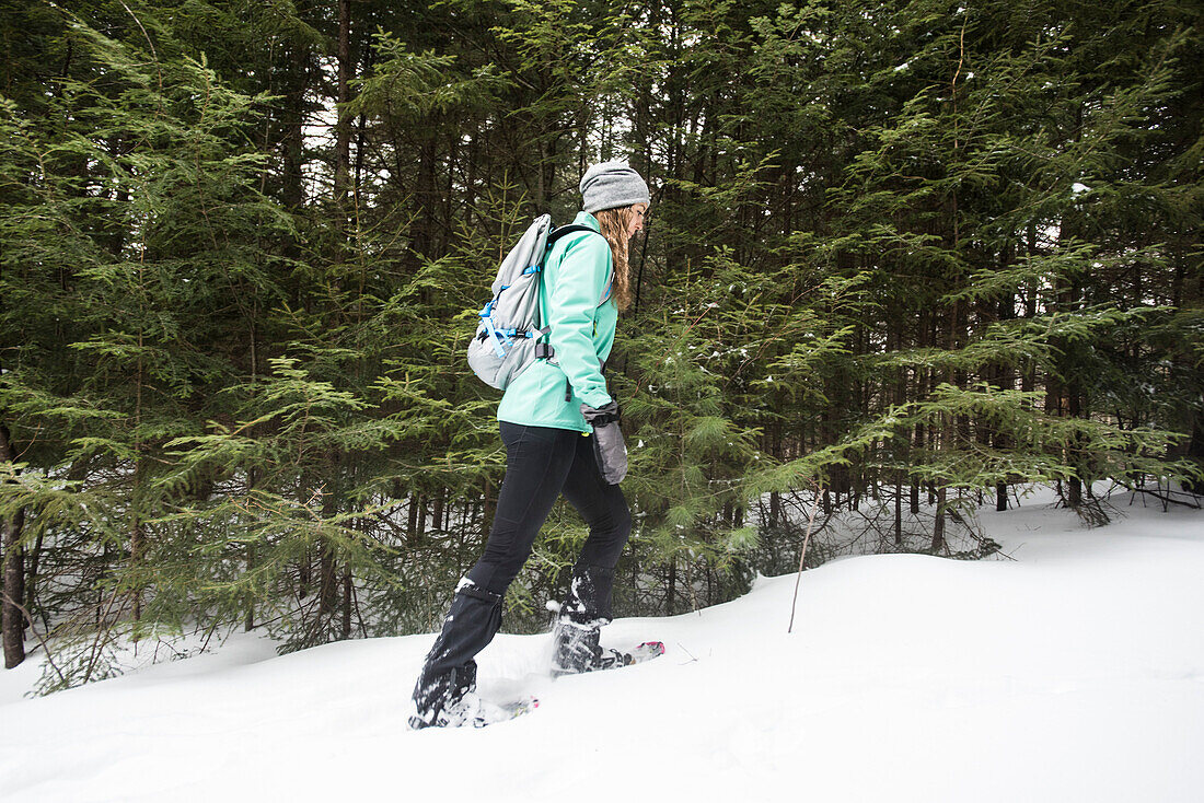 Woman snowshoeing in the woods.