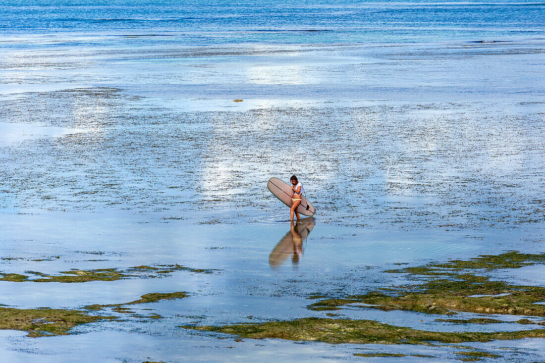 Female surfer walking in sea