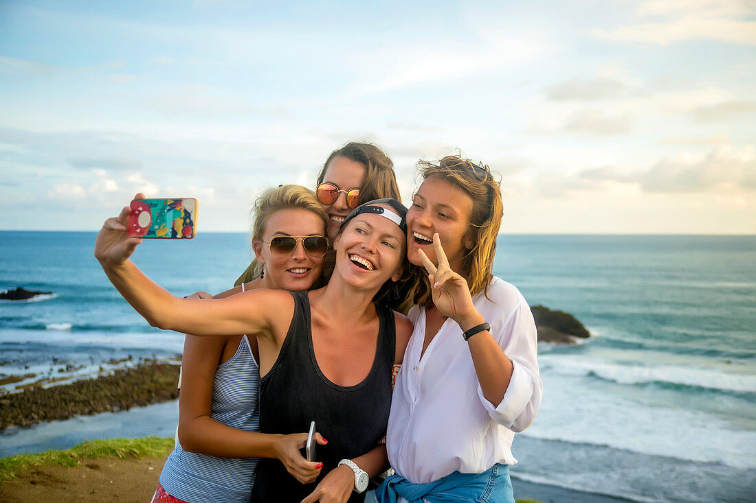 Friends taking selfie at ocean coastline