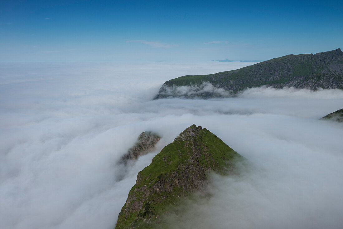 Berggipfel tauchen über Nebel in Unstad, Vestågøy, Lofoten, Norwegen auf