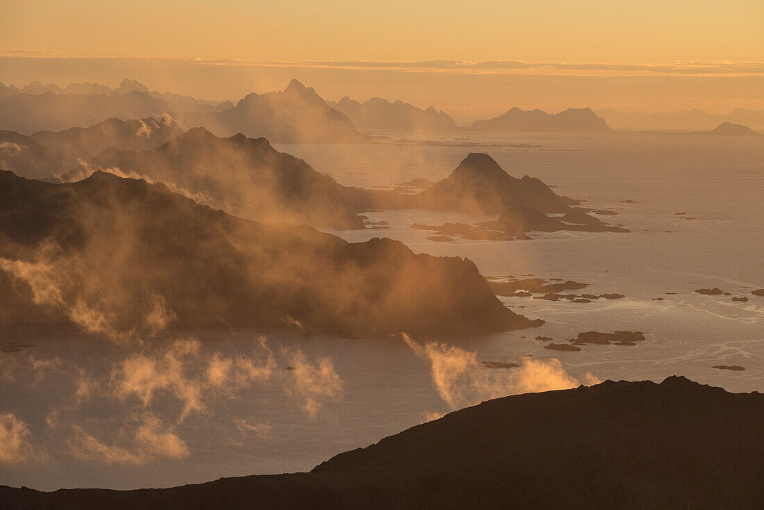 Herbstnebel bildet sich über Bergen bei Sonnenaufgang von Tønsåsheia, Lofoten-Inseln, Norwegen