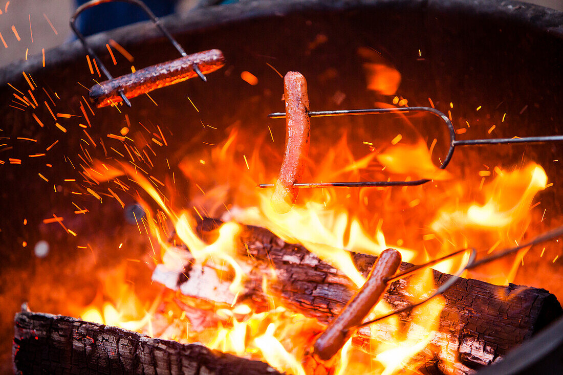 Hotdogs Kochen über ein Lagerfeuer.