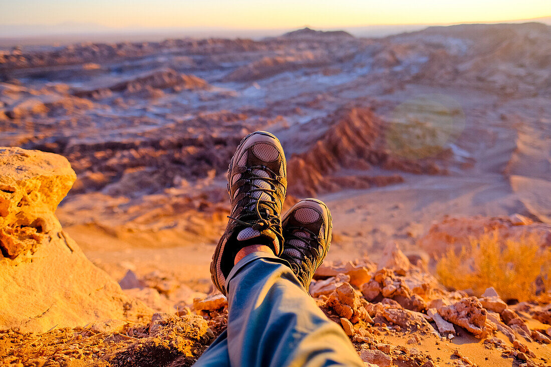 Hiker resting during sunset over Valle de La Luna in Atacama Desert outside of San Pedro de Atacama, Chile