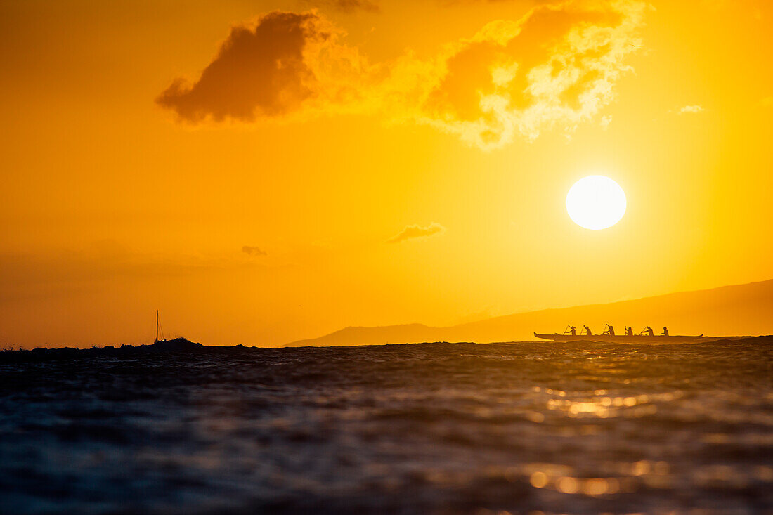 Gruppe von Männern Rudern im Meer bei Sonnenuntergang, Kaimana Beach, Honolulu, Hawaii, USA