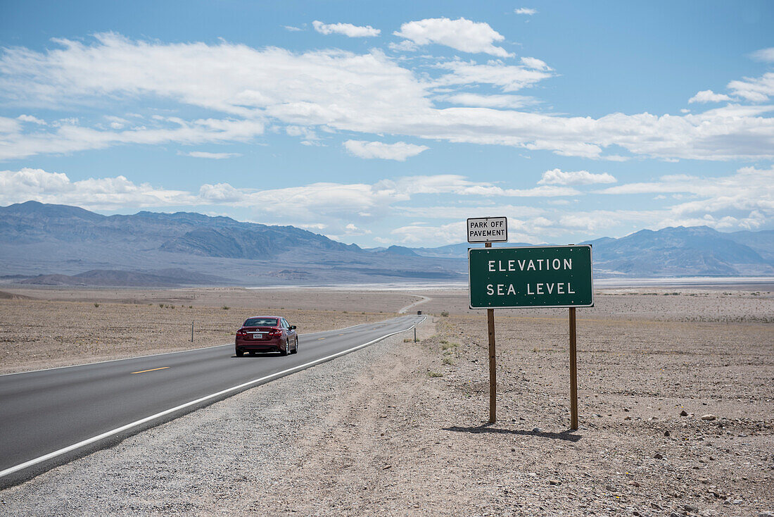 Car driving on road in Death Valley National Park at sea level, California, USA