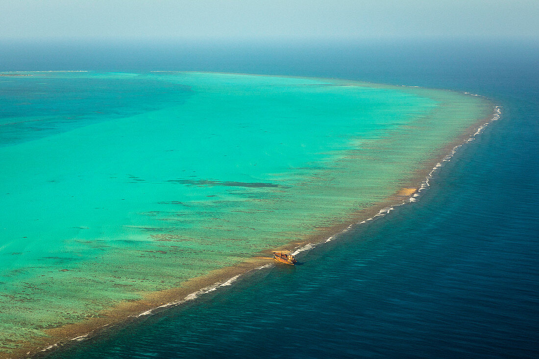 Erhöhte Ansicht des blauen Ozeans in Belize mit Schiff auf Riff geerdet