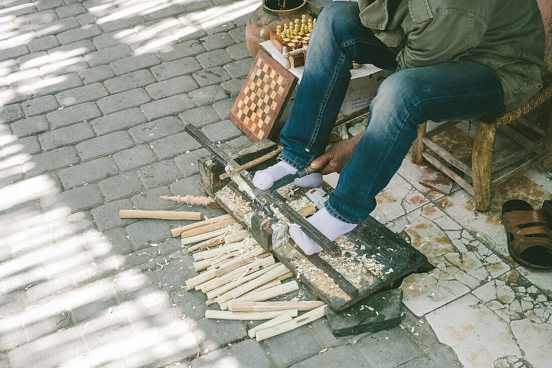 Low section of man carving wood on street of Marrakesh, Morocco