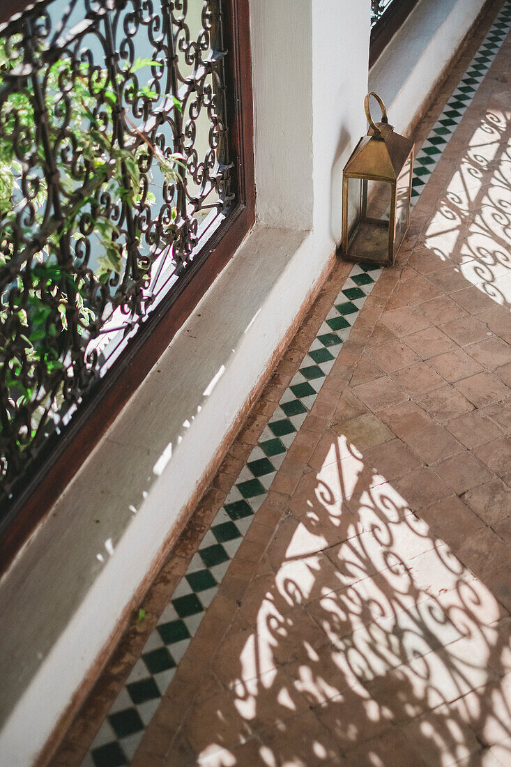 Details of Arabian architecture with railing casting shadow on pavement, Marrakech, Morocco