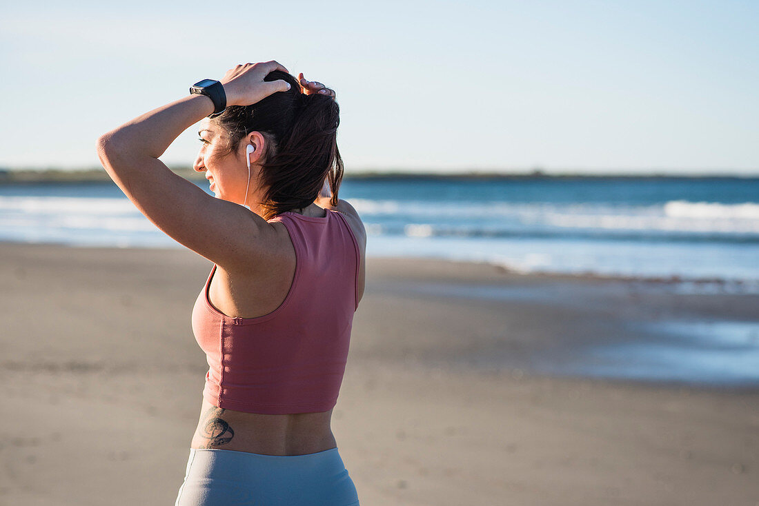 Woman in her twenties working out during an early morning on the beach in Newport, Rhode Island