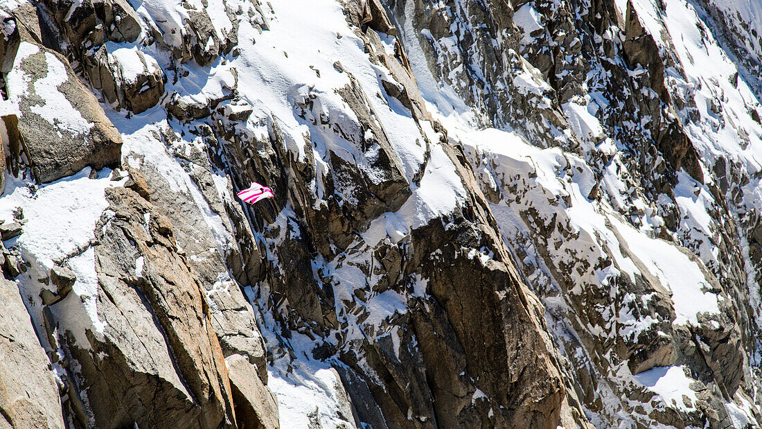 A Person Flying In A Wing Suit Against A Backdrop Of Sheer Rocky Cliff