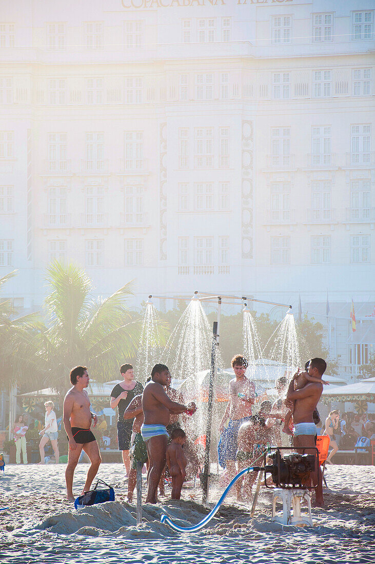 Männer und Kinder duschen am Copacabana-Strand in Rio de Janeiro, Brasilien