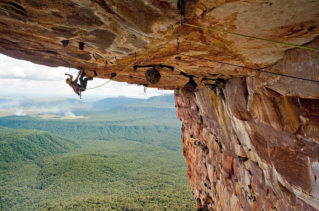 Adventurous rock climber hanging from rock ceiling, Amury Tepui, Bolivar, Venezuela