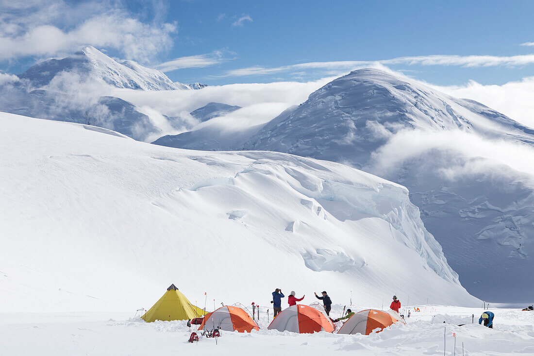 Bergsteiger treffen sich in einem Lager mit Zelten in 12.000 Fuß auf Denali, Alaska.