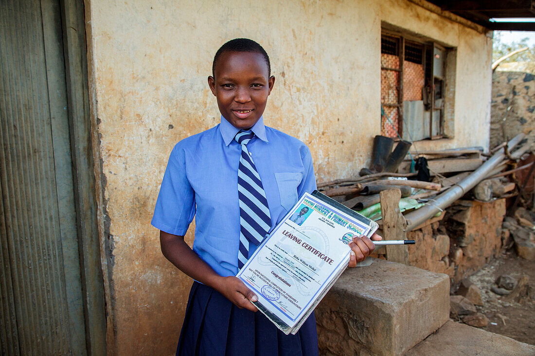 Ritha Mollel, Solar Sister Julieth Millelâ€™s 14-year-old granddaughter, holds her certificate of graduation form her primary school. Because of Juliethâ€™s work with Solar Sister Julieth is able to help pay the school fees for her granddaughter.    Julie