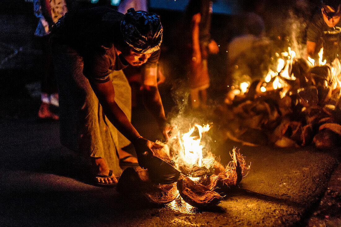 Person brennende Kokosnussschalen in der Nacht, Tabanan, Bali, Indonesien