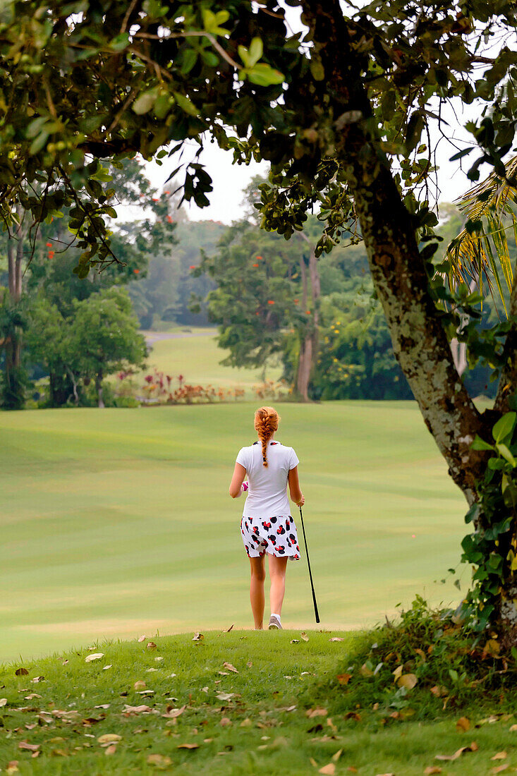 Young woman playing golf, Bali, Indonesia