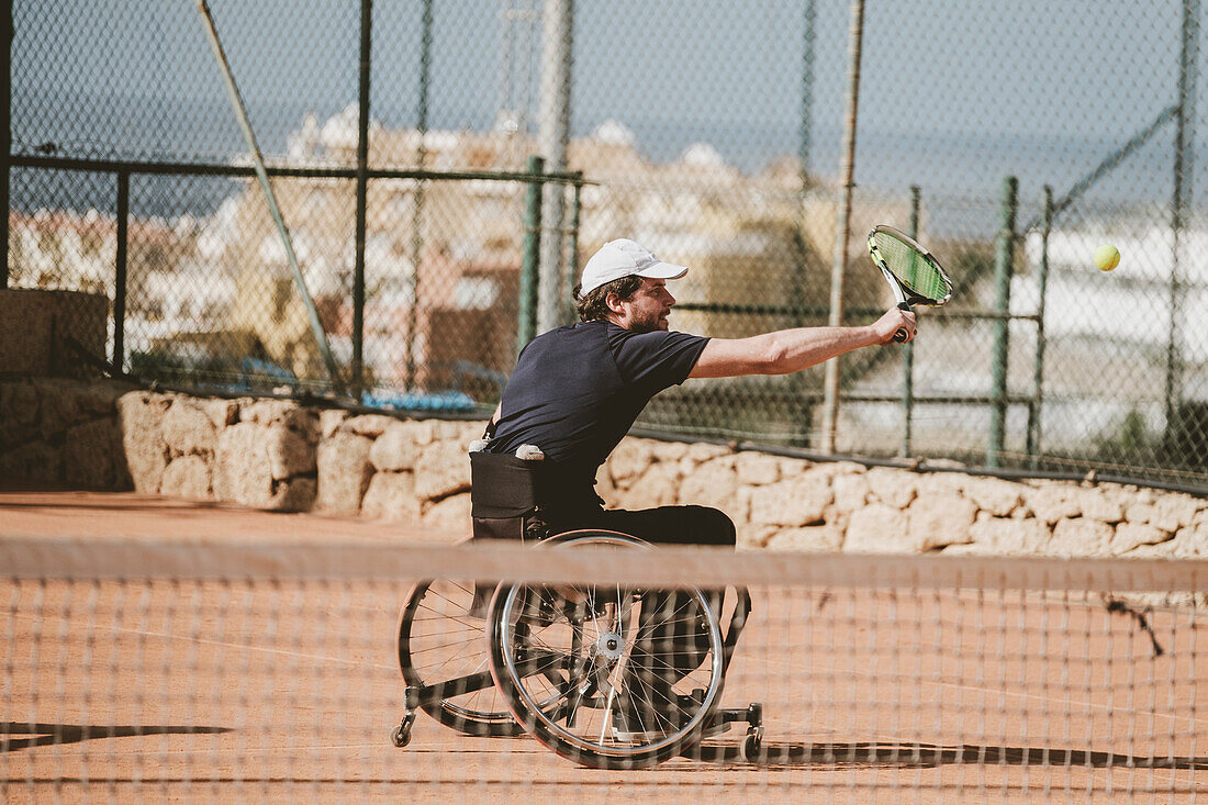 Mittlerer erwachsener österreichischer paralympic Tennisspieler, der auf Tennisplatz spielt