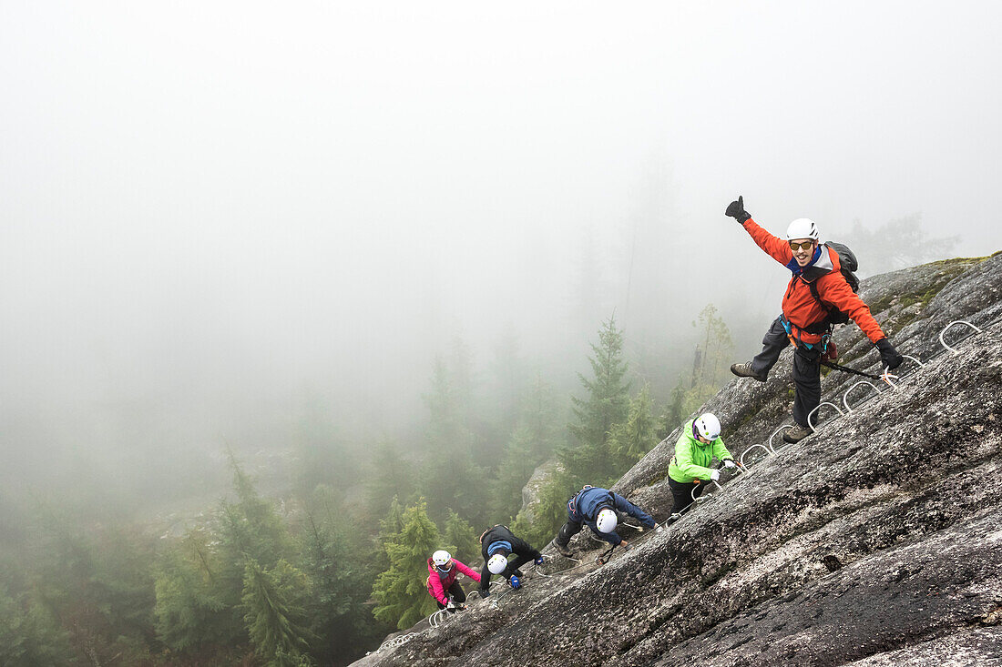 A group of people enjoy a Via Ferrata on a rainy fall day Squamish, British Columbia.