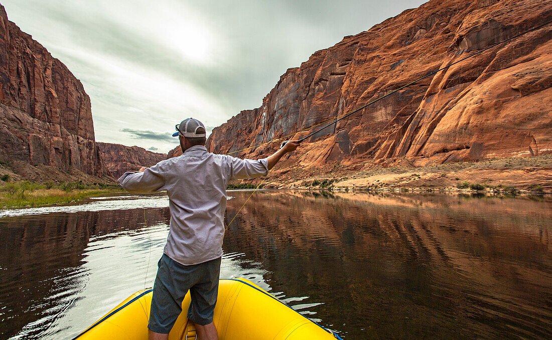 Rear View Of Man Fishing Off The Raft In The Grand Canyon