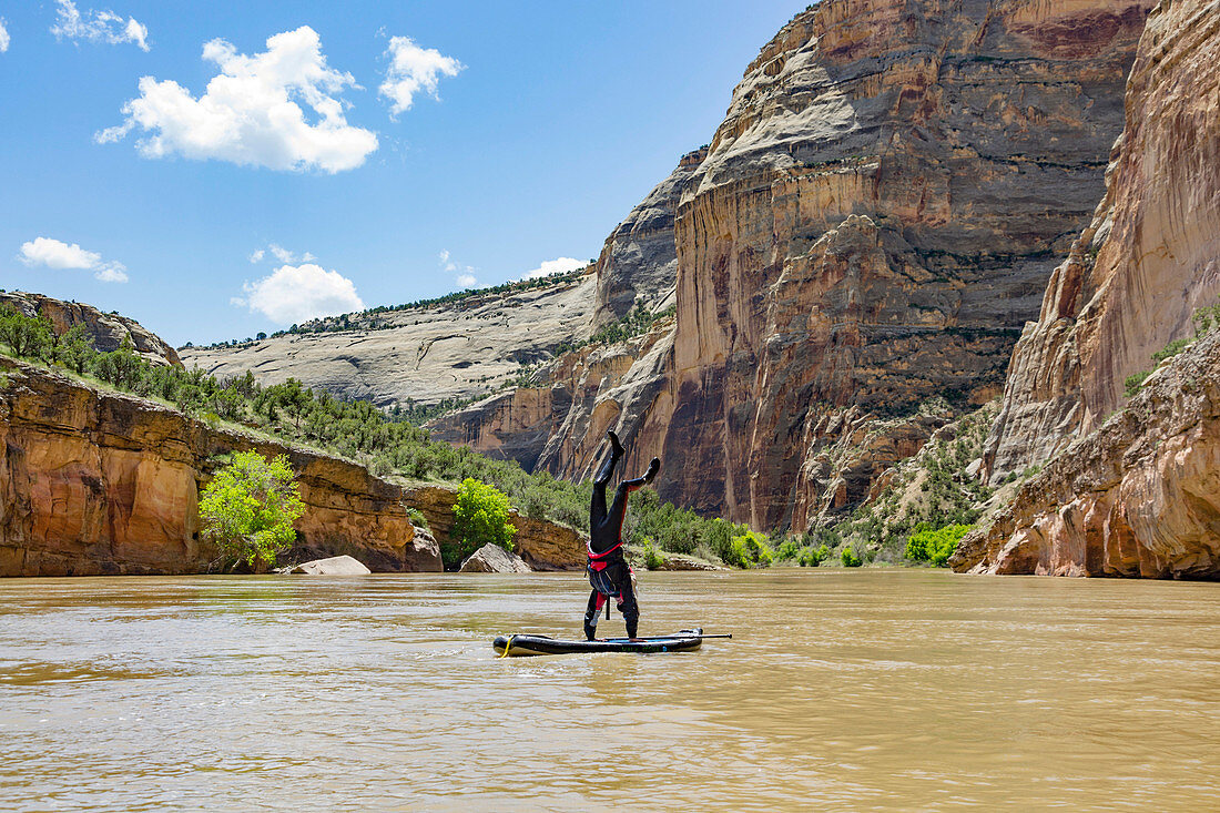 Person Doing Handstand On Standup Paddleboard, Green River, Utah