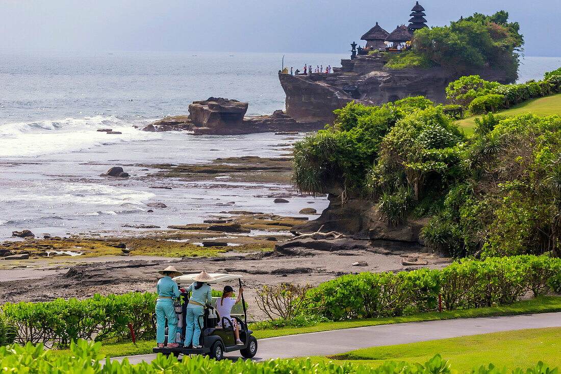 Golf cart at golf fields with Tanah lot temple in background,Bali,Indonesia