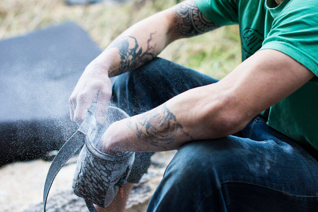 A Male Climber Chalks Up His Hands As He Prepares For A Climbing In Chihuahua