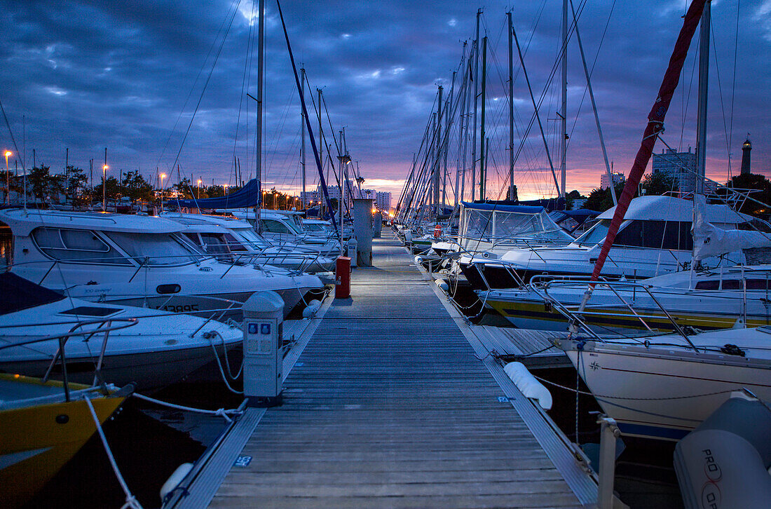 'Bewölkter Sonnenuntergang auf einem Jachthafen in Lorient. Lorient; Breton: Ein Oriant, ist eine Kommune und ein Seehafen im Departement Morbihan in der Bretagne im Nordwesten Frankreichs.'