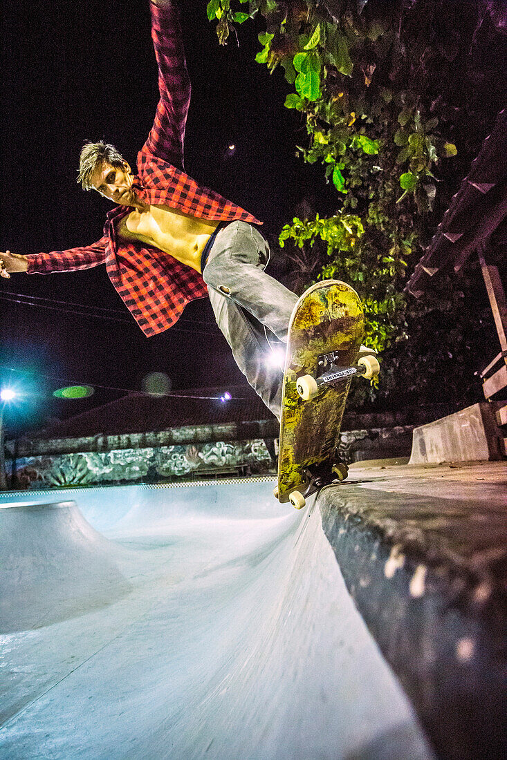 Skateboarder riding in skate pool, Jimbaran, Bali, Indonesia