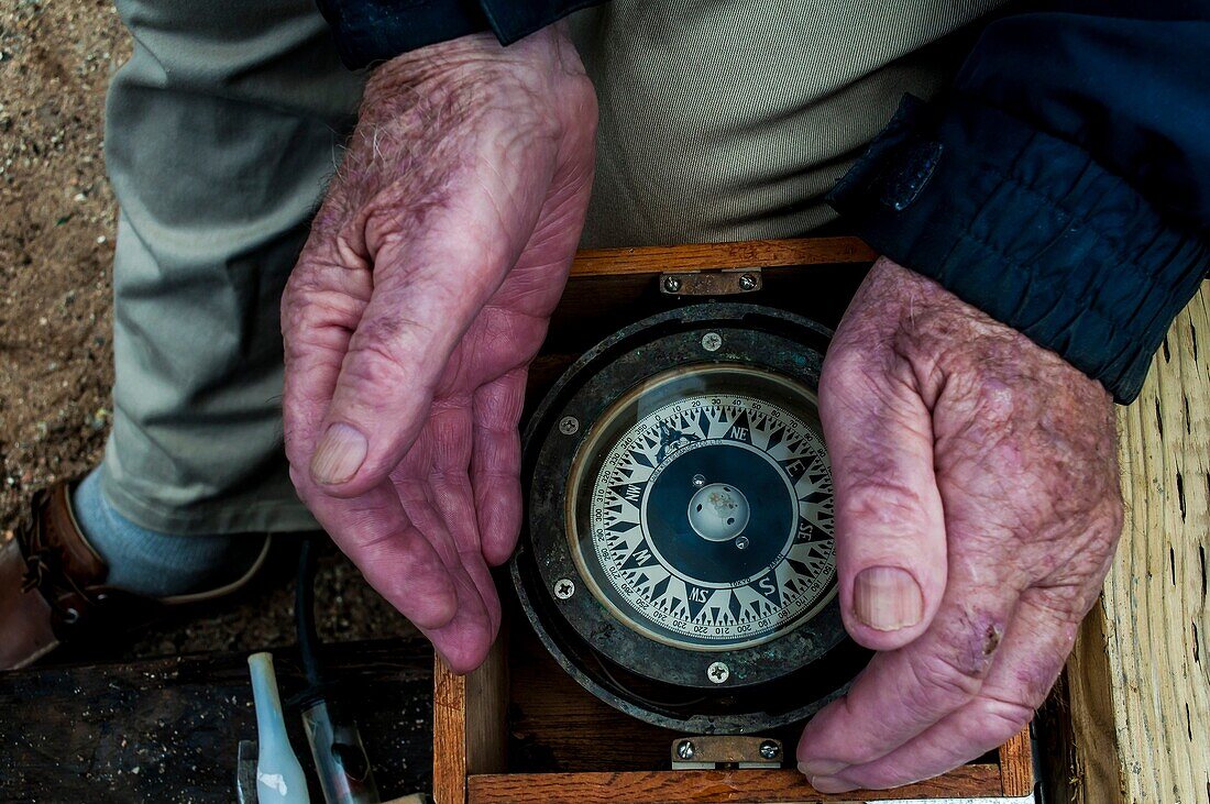 Ein alter Seemann Cups seine Hände um einen antiken Kompass, Halifax, Nova Scotia, Kanada