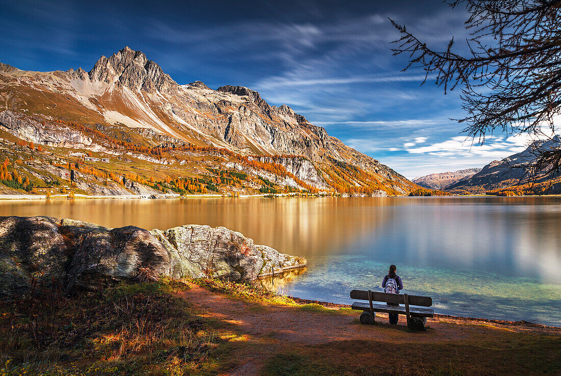 Hiker take relax admiring Lake Sils, Engadine, Canton of Graubunden, Switzerland, Europe