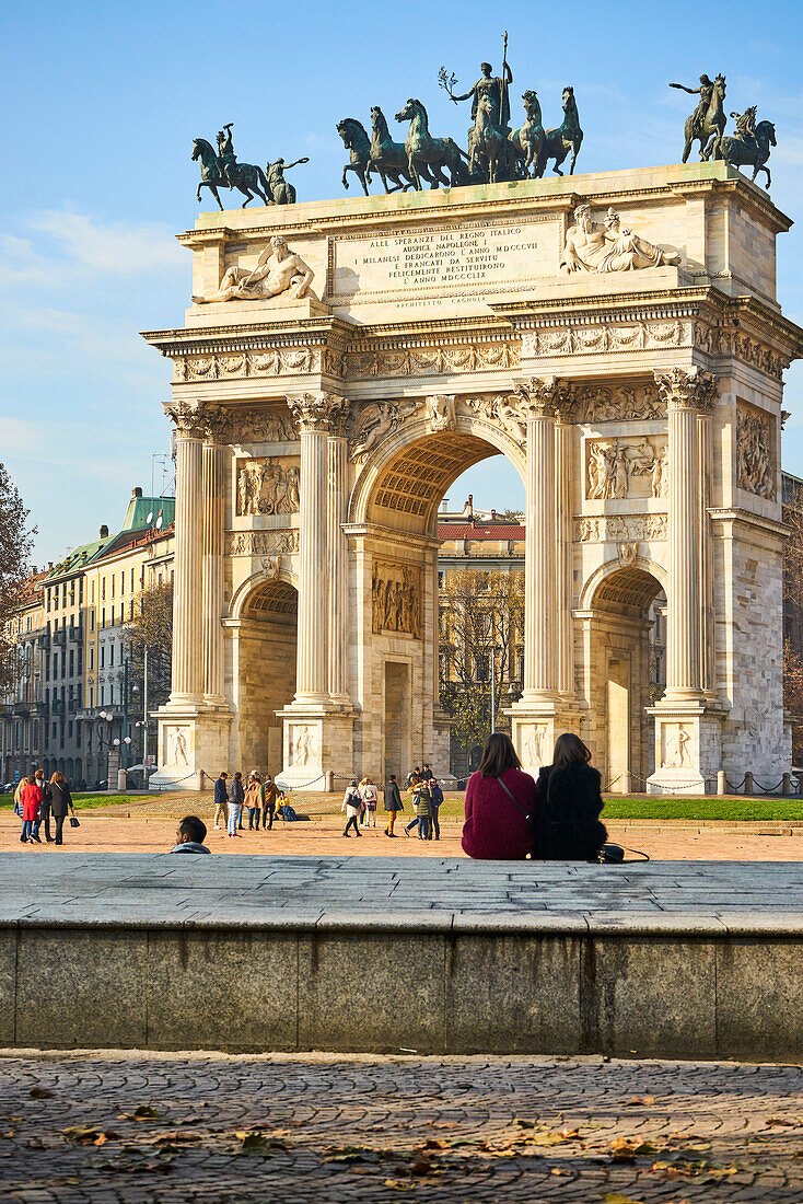 Mailand, Lombardei, Italien, Mädchen sitzen vor dem Bogen des Friedens