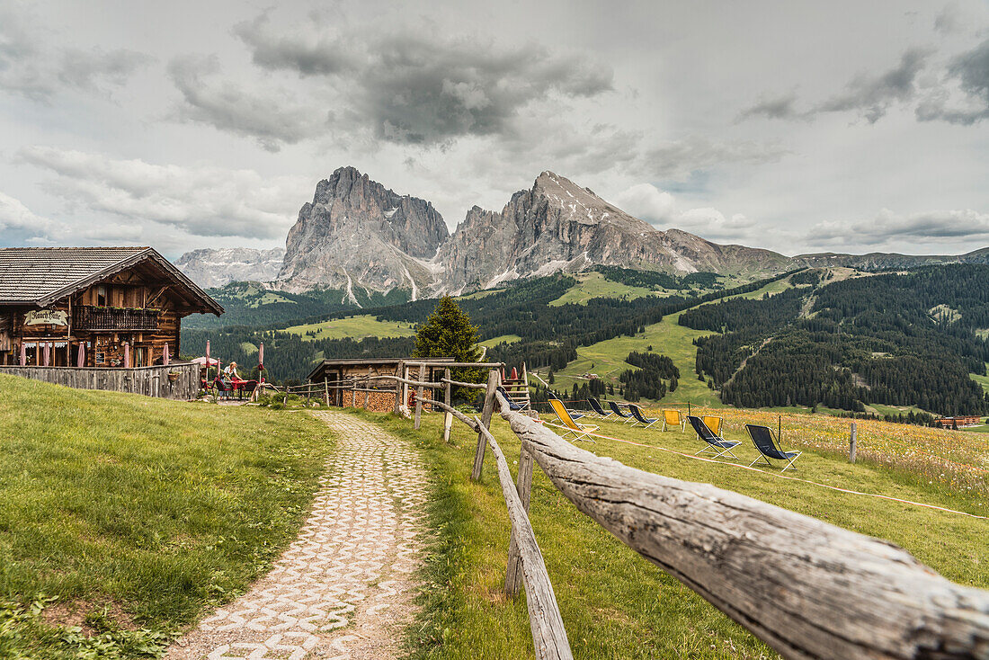 Alpe di Siusi/Seiser Alm, Dolomites, South Tyrol, Italy, View from the Alpe di Siusi to the peaks of Sassolungo/Langkofel and Sassopiatto / Plattkofel with Rauch Hutte on the left