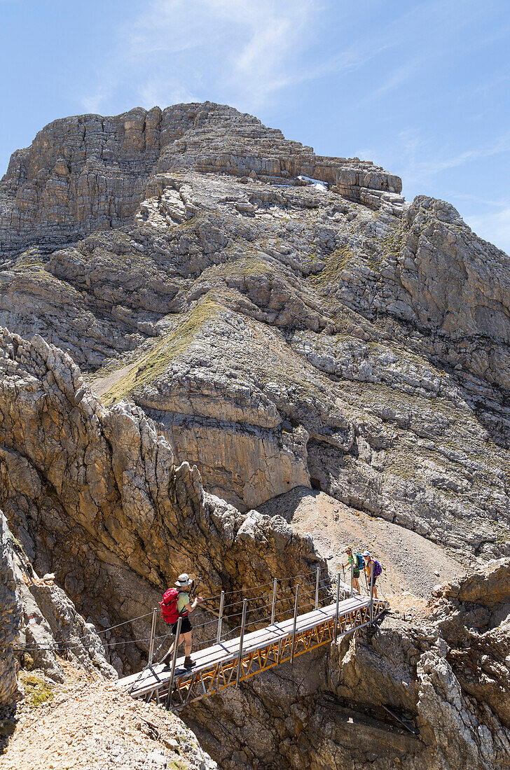 Italy,Veneto,Belluno district,Cortina d'Ampezzo,Hiker crosses a short suspended bridge on the trail to Mount Croda del Vallon Bianco