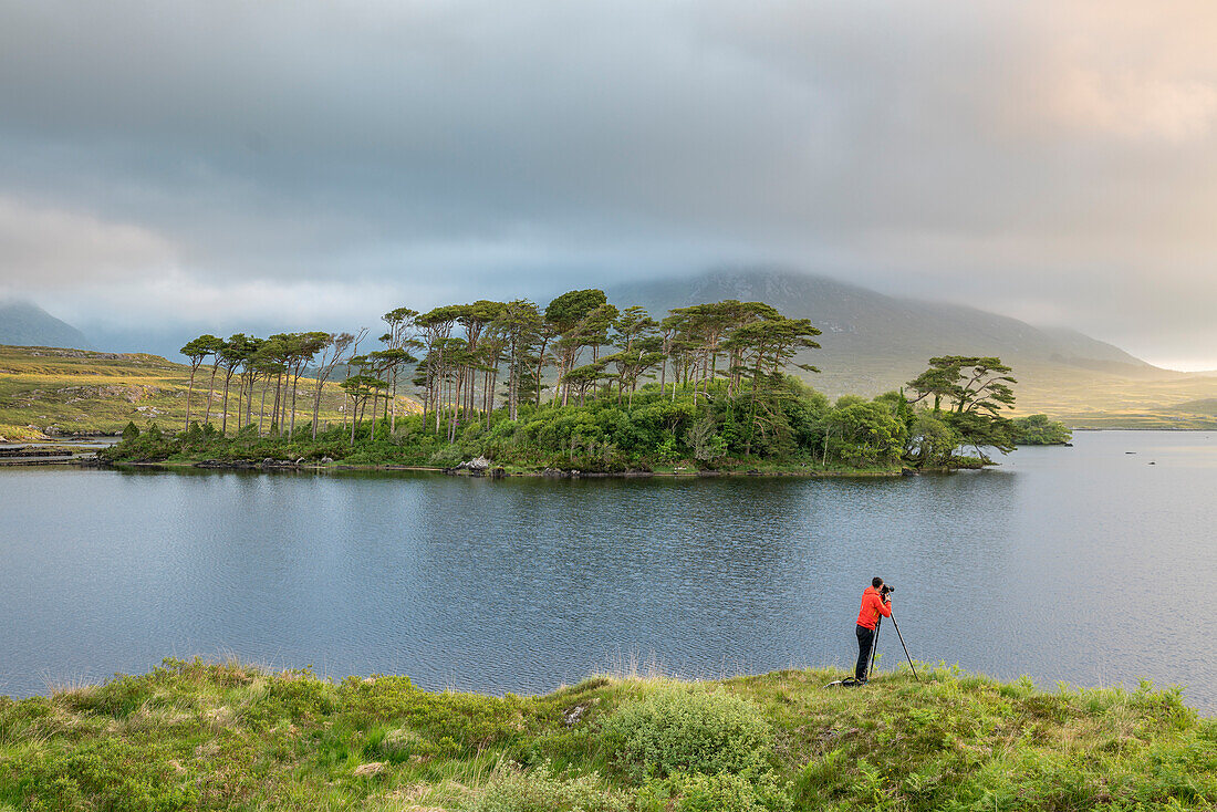 Fotograf vor Pine Island am Derryclare See, Connemara, Co, Galway, Connacht Provinz, Irland