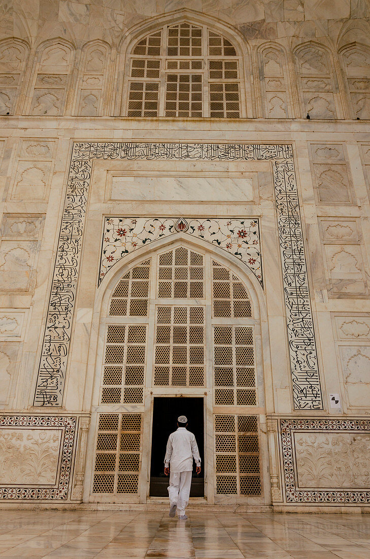 Agra, Uttar Pradesh, Indien, Ein Mann, der traditionelle weiße Kleidung trägt, geht in den Taj Mahal